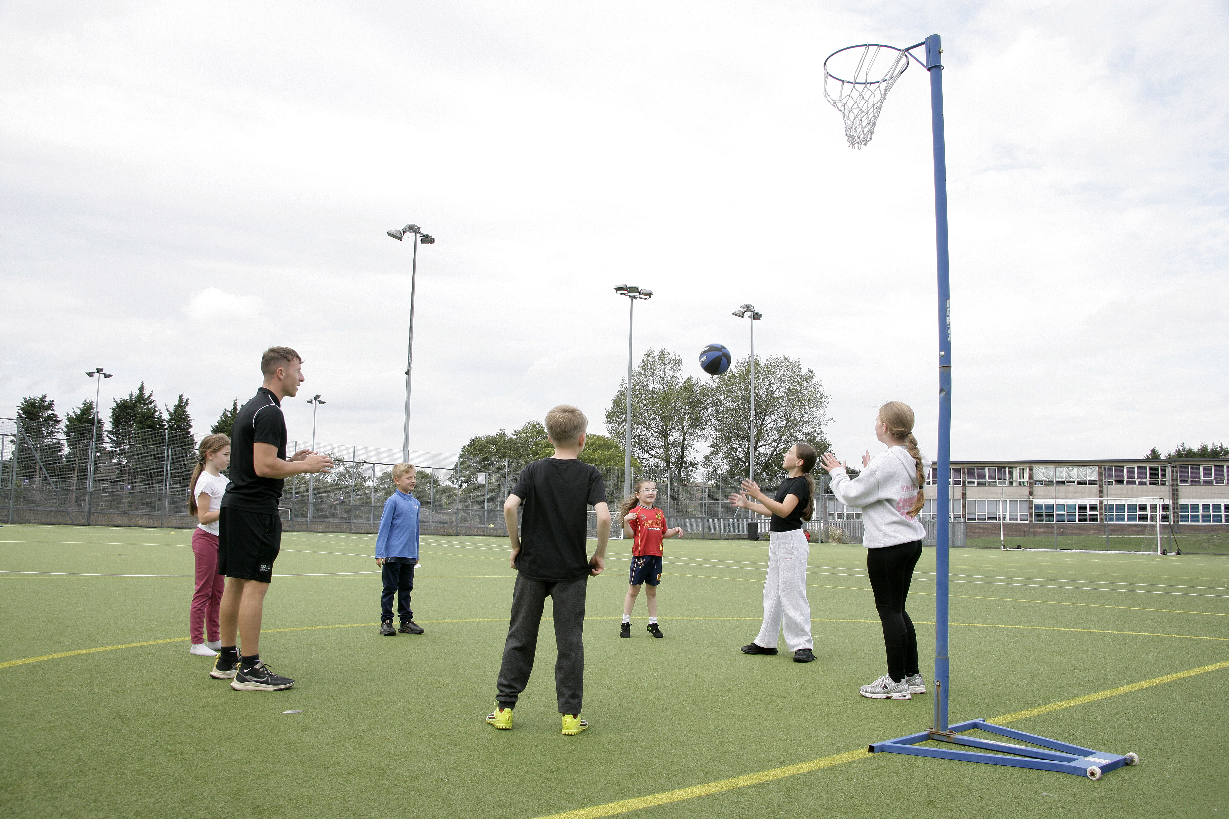 A coach leading a group ball game with children at holiday camp